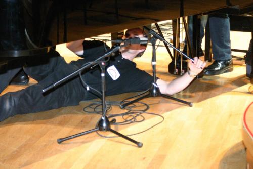 Adjusting the microphone under the grand piano